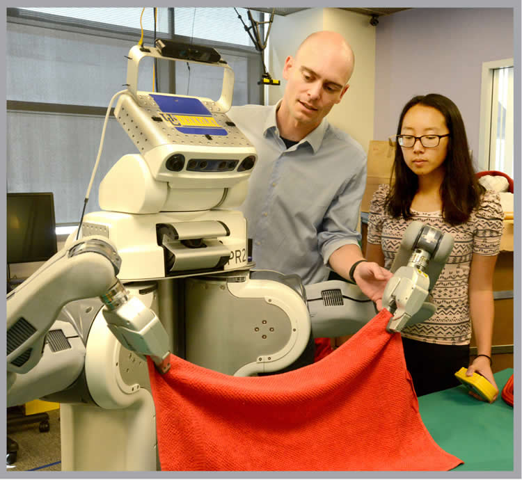 Image shows BRETT the robot folding a towel.