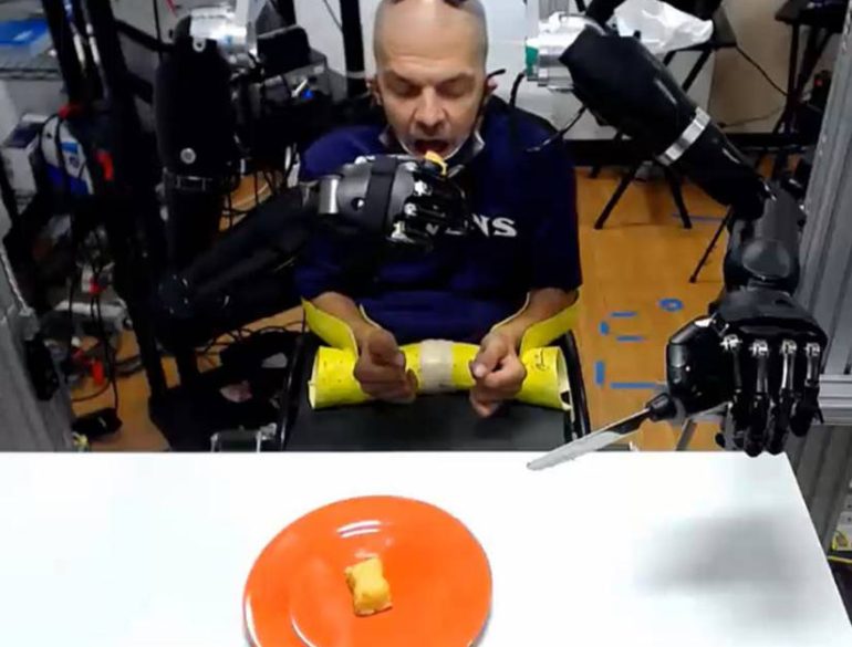 This shows the patient using the robotic arms to feed himself