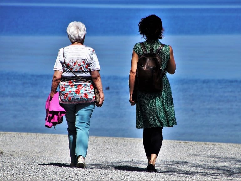 This shows two women walking on a beach