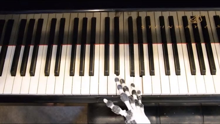 the robotic hand playing a piano