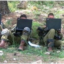 The image shows two soldiers performing a computer test,