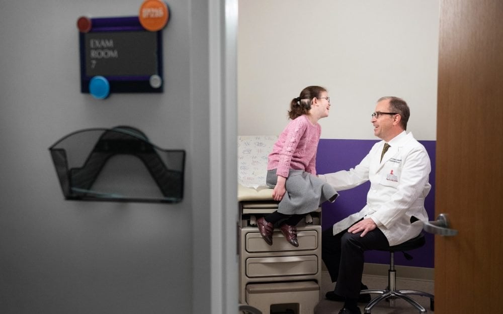 A doctor is seen talking to a young girl.