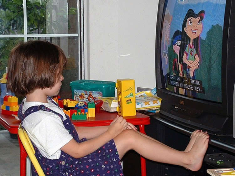 Image shows a kid watching TV.
